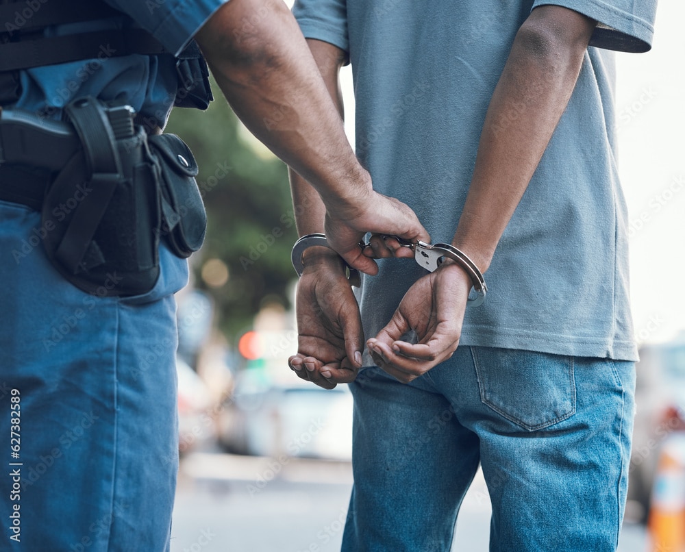 A police officer handcuffs a person from behind | Weygandt Law LLC
