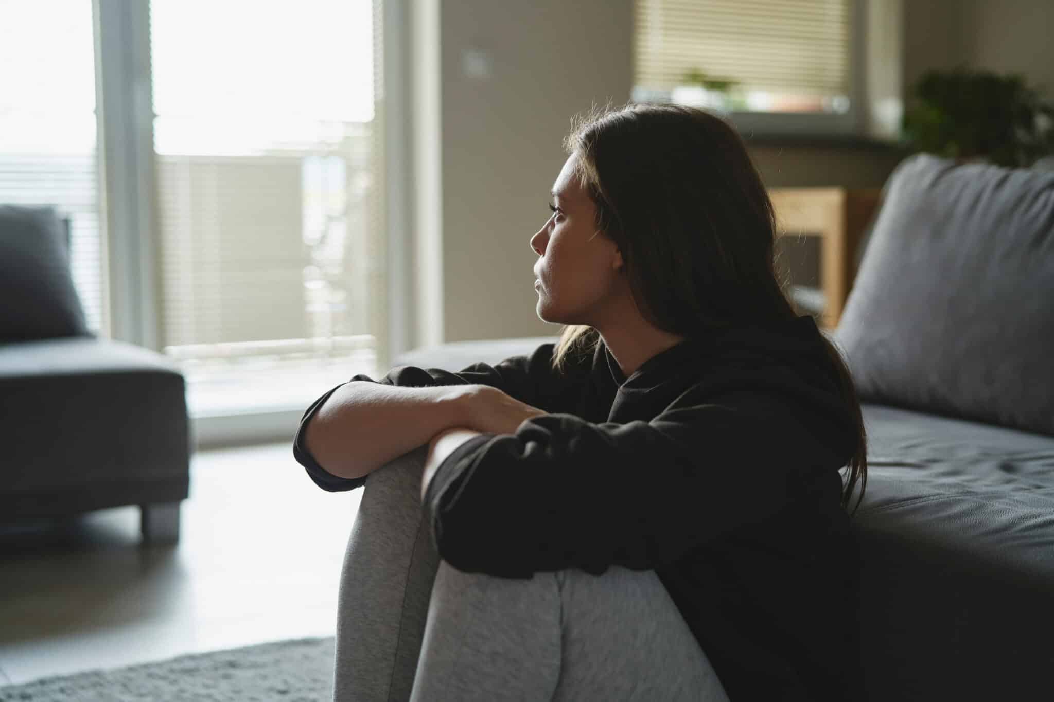 Woman sitting on the floor at home | Weygandt Law LLC